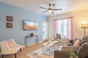 A living room with a ceiling fan, a sofa, a chair, a coffee table, and a TV. - Heated Pool | Walk to Westin Kierland - Park-W/D (Scottsdale)