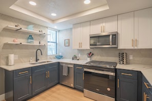 A modern kitchen with dark cabinets, a stainless steel microwave, and a built-in oven. - Heated Pool | Walk to Westin Kierland - Park-W/D (Scottsdale)