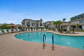 A swimming pool with lounge chairs and a building in the background. - Heated Pool | Walk to Westin Kierland - Park-W/D (Scottsdale)