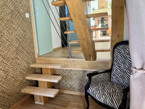Eine Treppe mit hölzernen Stufen und ein Sessel mit ZEBRA-Muster.