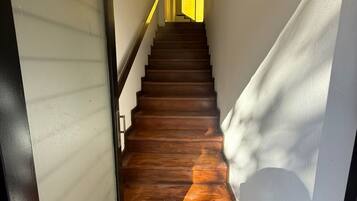 A staircase with wooden steps leading to a room with a door.