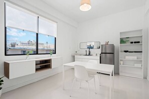 Eine moderne Küche mit weißer Arbeitsplatte, Edelstahlgeräten und einem großen Fenster mit Blick auf die Stadt.