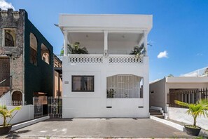 A modern white building with a balcony, a gated entrance, and a clear sky. - San Rafael Apt 8 | Elegant 1 BR Stay @ San Juan (San Juan de Puerto Rico)