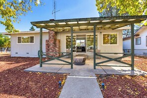 A covered outdoor seating area with a brick fireplace, a pergola, and a view of a residential building. - Clearlake Oaks - Boat Slip, Views (Clearlake Oaks)