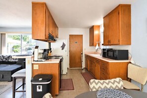 A compact kitchen with wooden cabinets, a stove, a microwave, and a coffee maker. - Clearlake Oaks - Boat Slip, Views (Clearlake Oaks)
