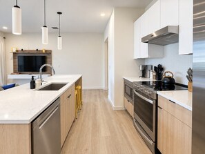 A modern kitchen with a central island, stainless steel appliances, and pendant lighting. - Bluebird By Broadway in Downtown Nash & Enjoy Pool, Gym, Parking. Walk to Broadway! (Nashville)