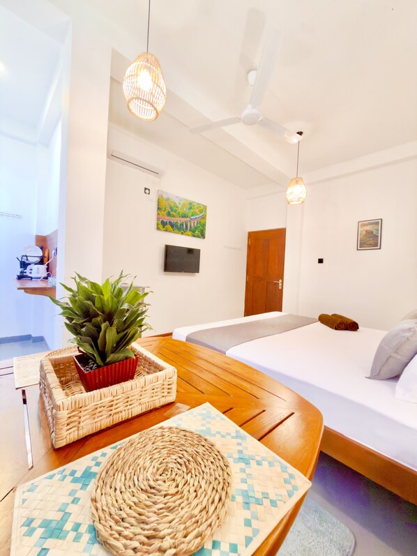 A modern hotel room with a bed, a wooden table, a potted plant, and two pendant lights. - Crystal Pearl Villa Weligama (Weligama)