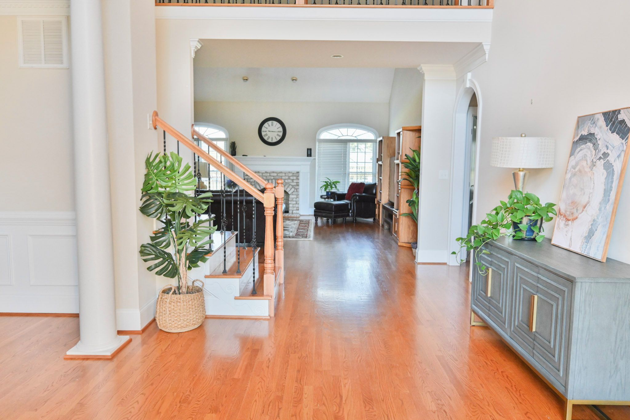 A spacious interior with a wooden staircase, a fireplace, and a dining area.