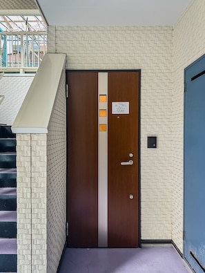 A wooden door with a vertical stripe, a small sign, and a doorbell. - HANASTAY MITSUHA & SEIRAN (Osaka)