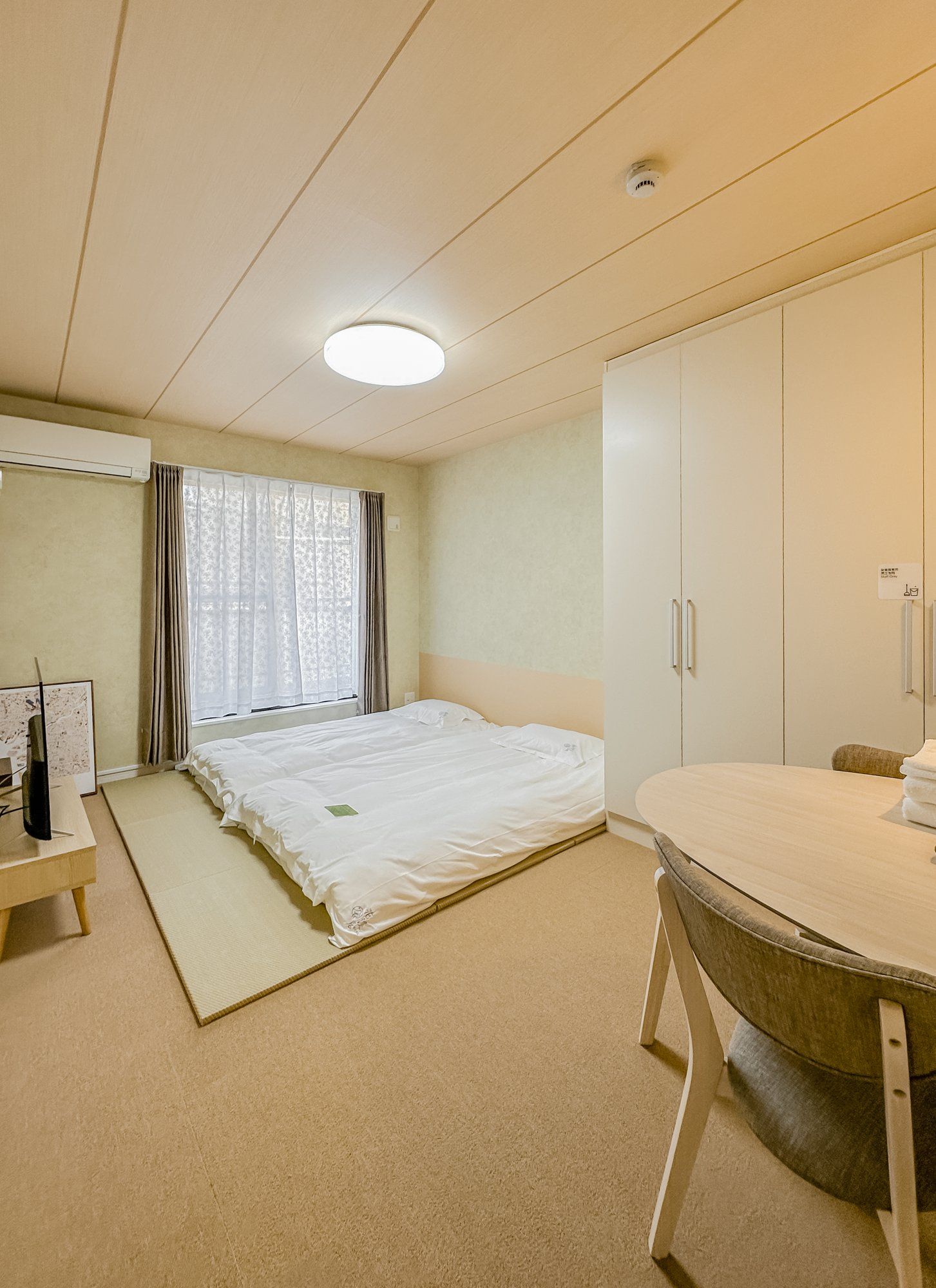 Una habitación de hotel con cama, escritorio, armario y baño.