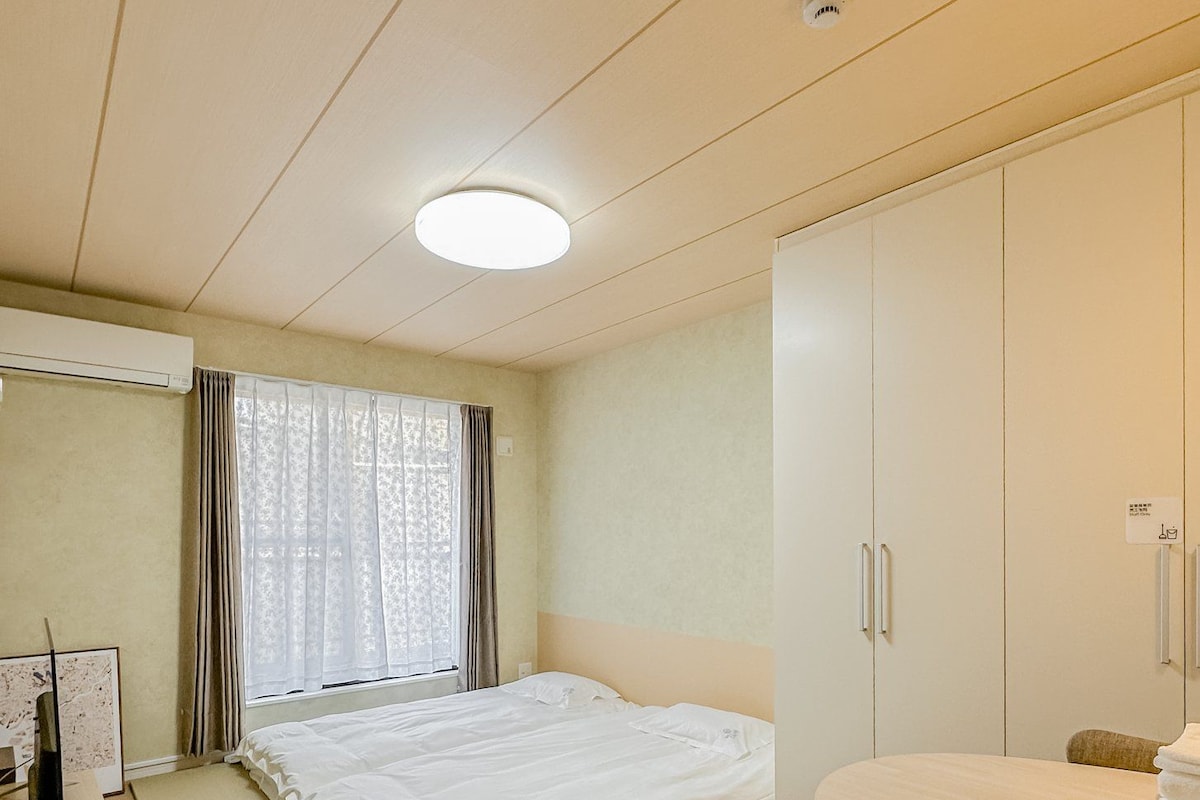 A hotel room with a bed, a desk, a wardrobe, and a bathroom.