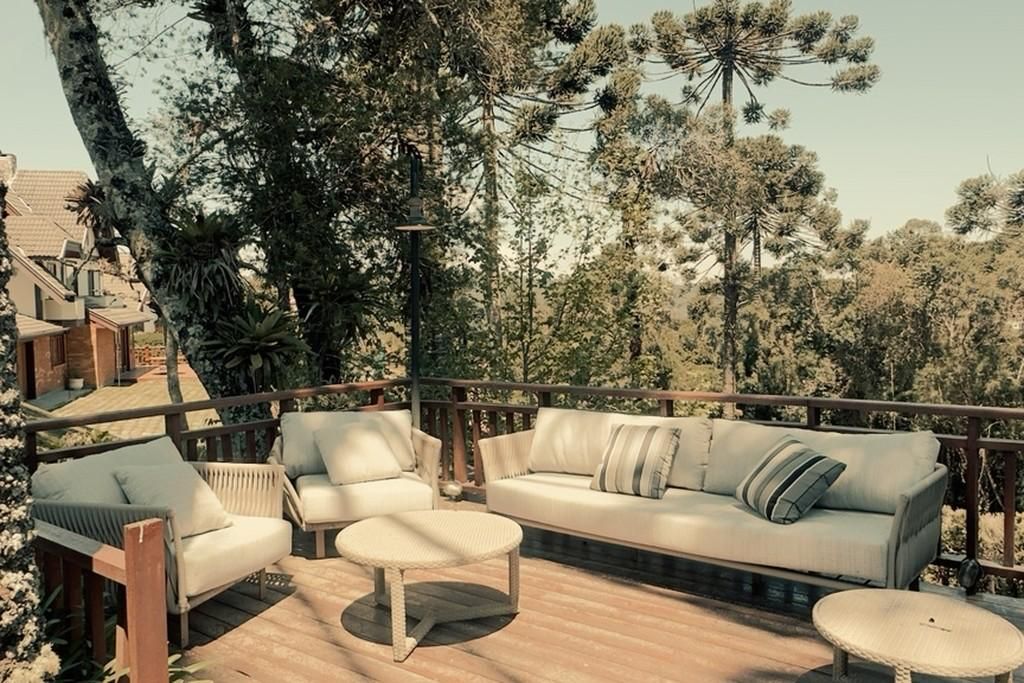 An outdoor seating area with a sofa, chairs, and a small table.