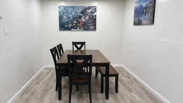 Une salle de conférence avec une table rectangulaire et quatre chaises, des murs blancs et deux tableaux.