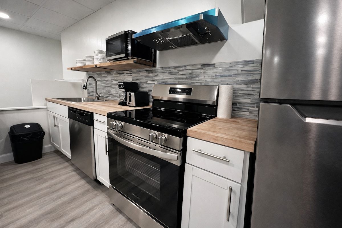 A modern kitchen with stainless steel appliances, a microwave, and a coffee maker.