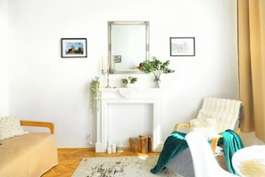 A room with a white fireplace, a mirror above it, and two framed pictures on the wall. - Krakow Old Town Within Easy Reach - Kazimierz Apartment (Kraków)
