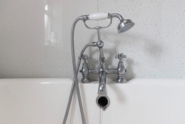 Ein Badezimmer mit einer Duscharmatur im Vintage-Stil und einer Handbrause.