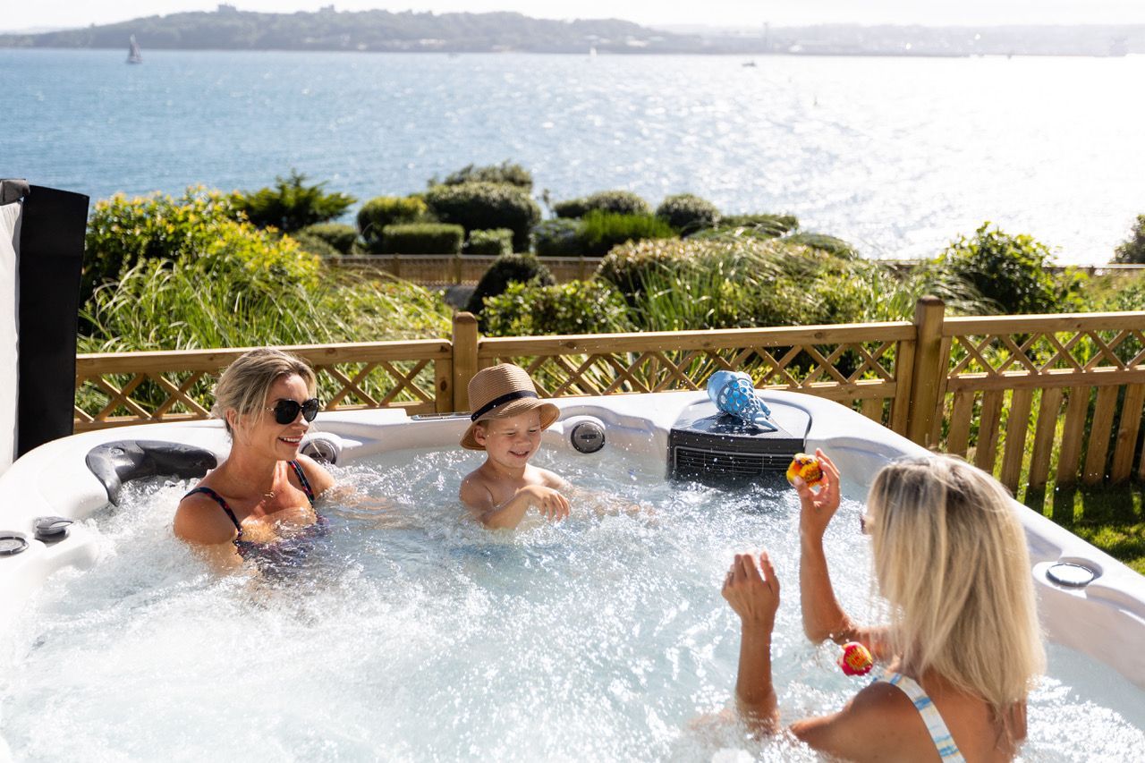 Un jacuzzi con vistas al mar, rodeado de vegetación.