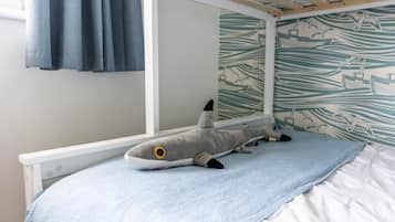 A bunk bed with a plush shark toy on the lower bunk.
