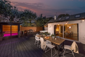 An outdoor patio with a wooden deck, a dining table with chairs, and a barbecue grill. - Meadow Retreat - Sleeps 12 | 4 Bedrooms | Hot Tub | Sauna | Cinema Room | Games Room | Dog Friendly (Hatt, Saltash, Cornwall)