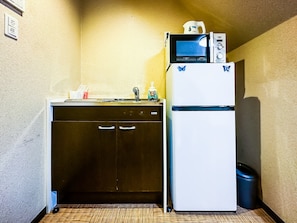 Une petite cuisine équipée d’un lave-vaisselle, d’un réfrigérateur et d’un four à micro-ondes.