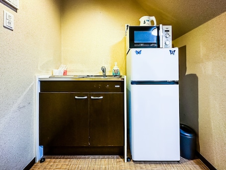 A compact kitchenette with a dishwasher, a refrigerator, and a microwave.