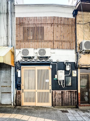A building facade with a wooden slatted wall, a metal door, and air conditioning units. - HANASTAY EBIYA HIGASHI (Osaka)