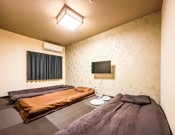 A hotel room with two beds, a flat-screen TV mounted on the wall, and an air conditioning unit. - HANASTAY EBIYA HIGASHI (Osaka)