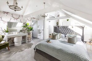 A modern bedroom with a sloped ceiling, a bed with multiple pillows, a desk with a chair, and a large window providing natural light. - The Valley Hideaway  - sleeps 2 guests  in 1 bedroom (Harrowbarrow, Callington)