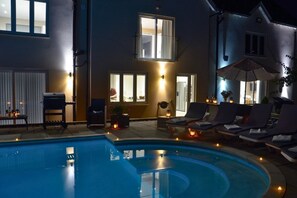 Ein Schwimmbecken mit Liegestühlen und einer Terrassenanlage.