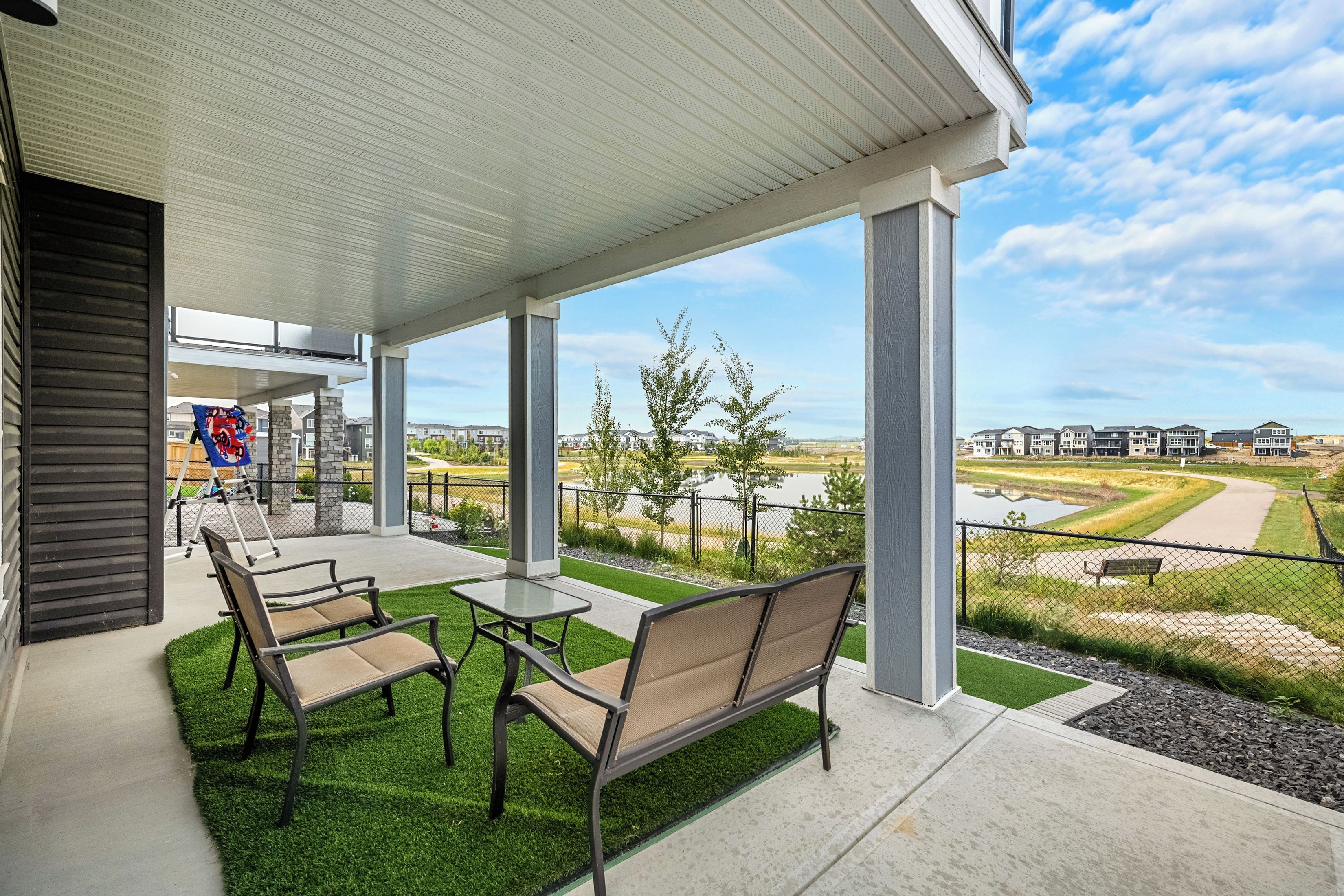 A covered patio area with outdoor seating and a view of a residential neighborhood.