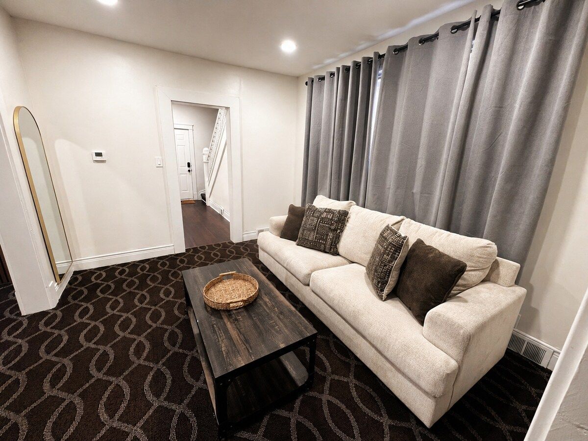 A living room with a sofa, a coffee table, and a patterned carpet.