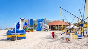 A beach with inflatable structures, including a shark and a blue and yellow inflatable. - 5BR, Private Pool, Near Pier 60 by Golden Coast Rentals (Clearwater)