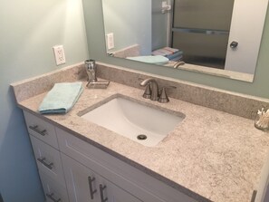A bathroom with a granite countertop, a sink, a mirror, and a towel. - Location...Location! Spacious Town Home Available for Seasonal Rental in Naples! (Naples)