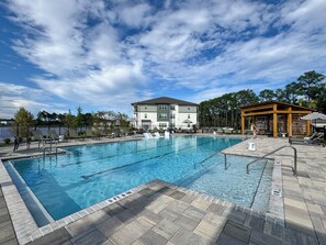 A swimming pool with a 3 FT 6 IN depth marking, surrounded by lounge chairs and a covered seating area. - Grand Boho Suite / Queen Bed-Pool-Gym Near Airpot (Jacksonville)