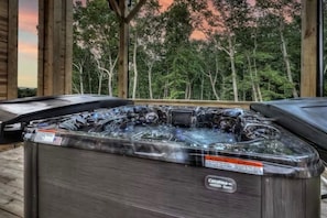 Ein Whirlpool mit dem Aufdruck 'Catalina Spa' auf einer Holzterrasse mit Blick auf Bäume.