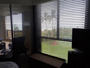 Ein Zimmer mit einem Bett, einem Schreibtisch und einem Fenster mit Jalousien.