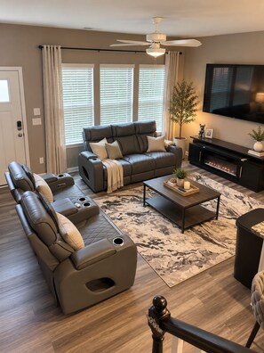A modern living room with a sectional sofa, a coffee table, and a flat-screen TV. - The Cozy Retreat Spacious Townhome Getaway in Charlotte (Charlotte)