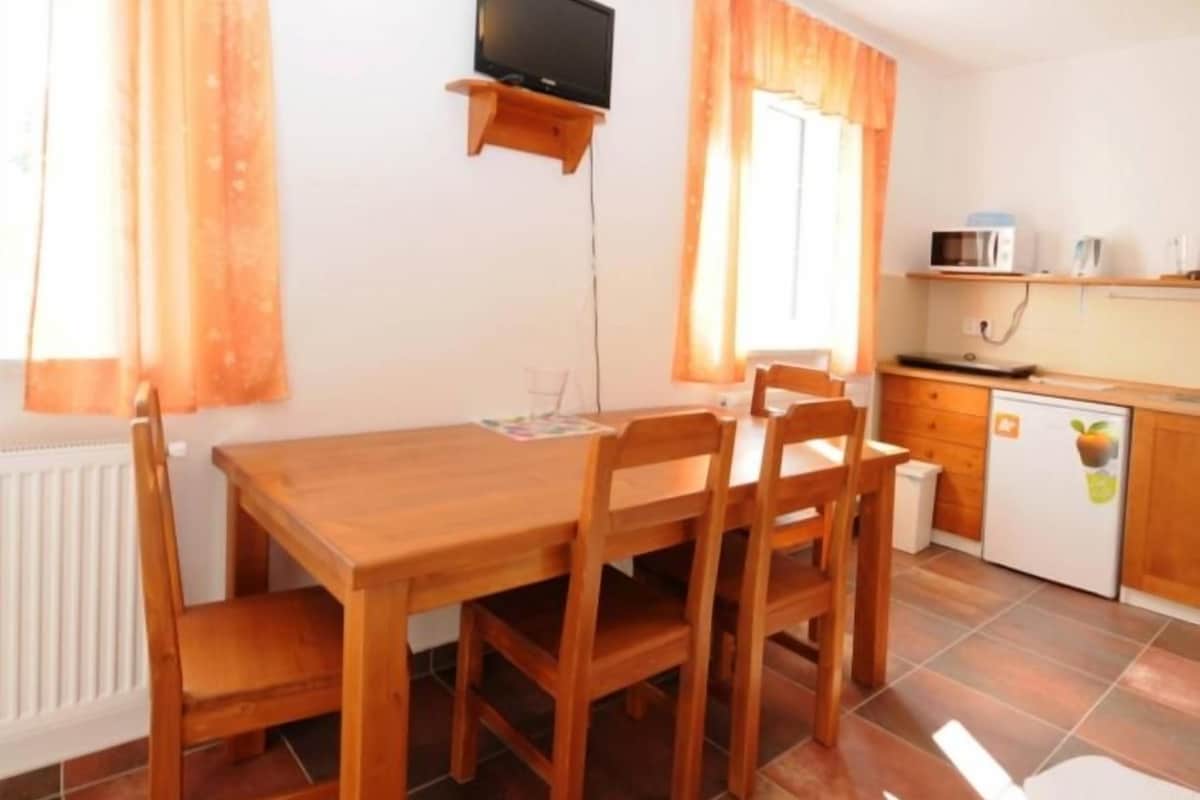 Una cucina compatta con forno a microonde, lavello e piccolo frigorifero.