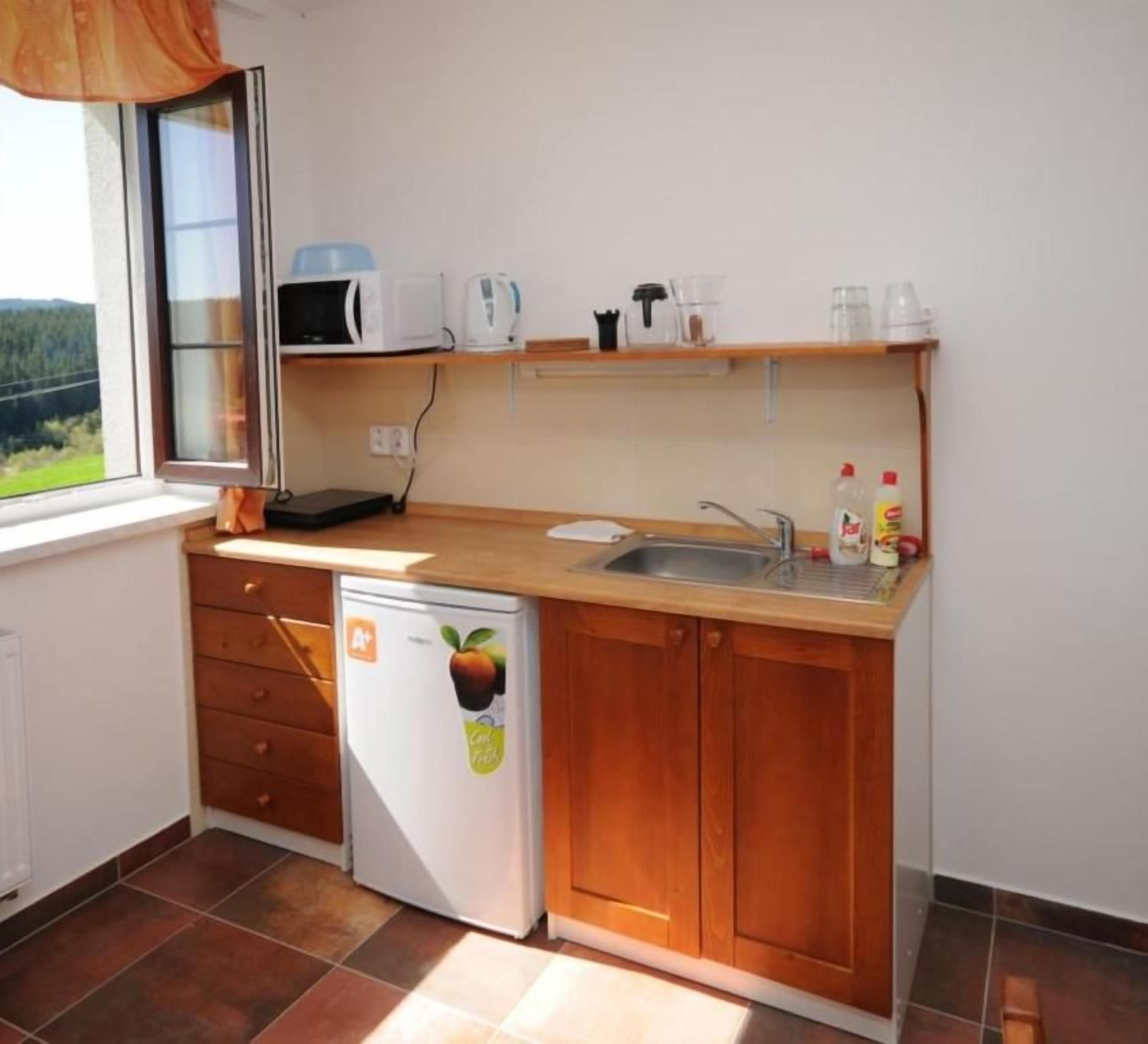 Een kleine keuken met een magnetron, broodrooster en een spoelbak.