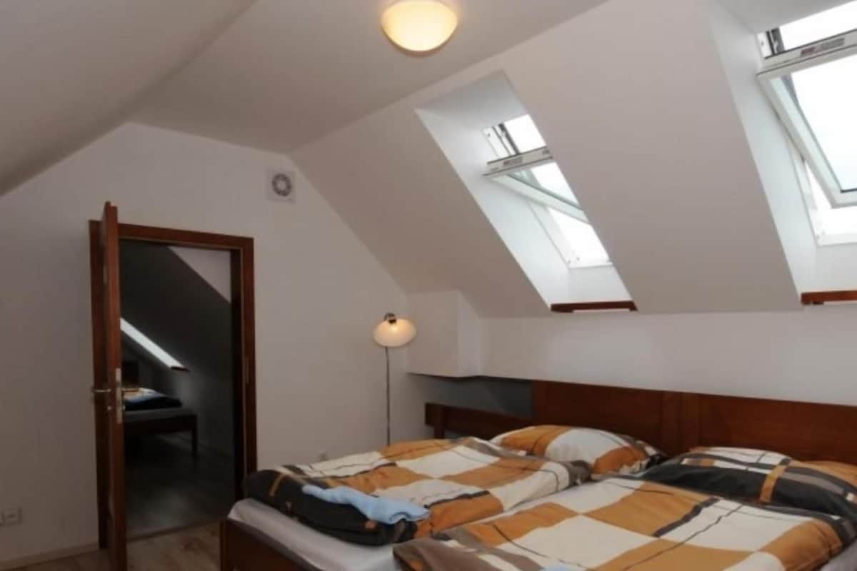 Una camera da letto con due letti, una cupola luminosa, uno specchio e una lampada da comodino.