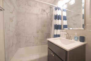 Un baño con bañera, lavabo y espejo.