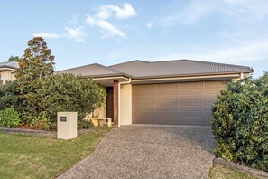 A residential house with a garage, a gravel driveway, and a mailbox. - Gold Coast Retreat Theme Parks Nearby (Pimpama)