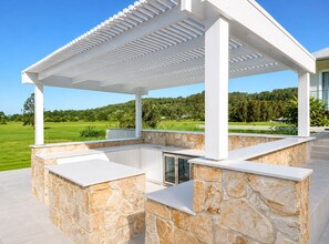 Eine moderne Außenpatio mit Steinwerkplatten und einer Pergola-Struktur.