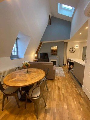 Eine Loft-Wohnung mit Essbereich, einer Couch, einem Kamin und einer Küchenzeile.