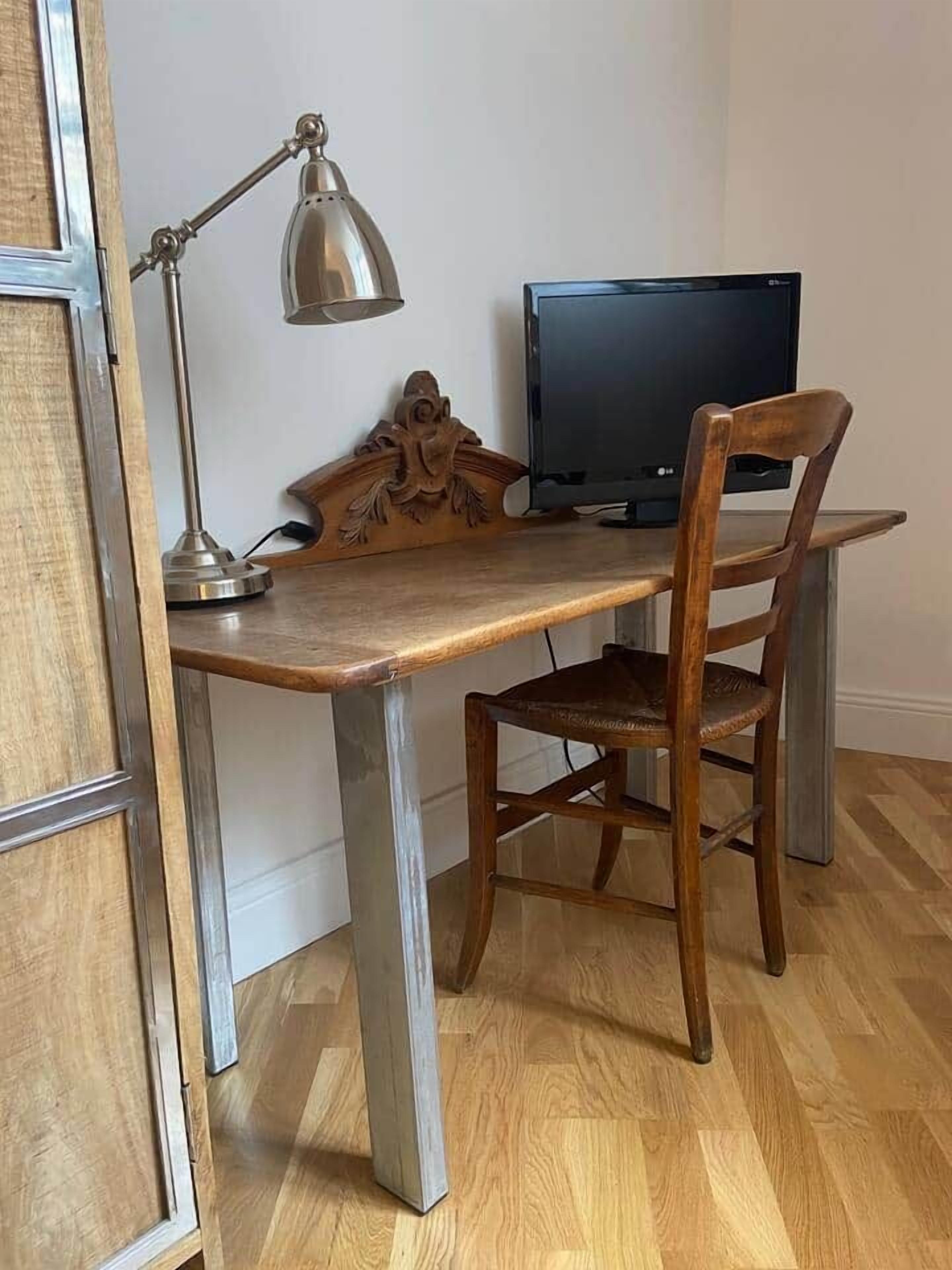 A wooden desk with a metal lamp and a television.