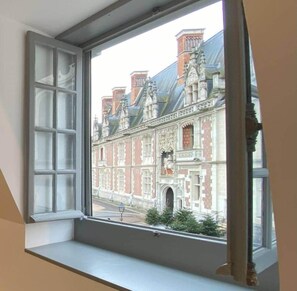 Ein Fenster mit Blick auf ein historisches Gebäude mit aufwendiger Architektur.