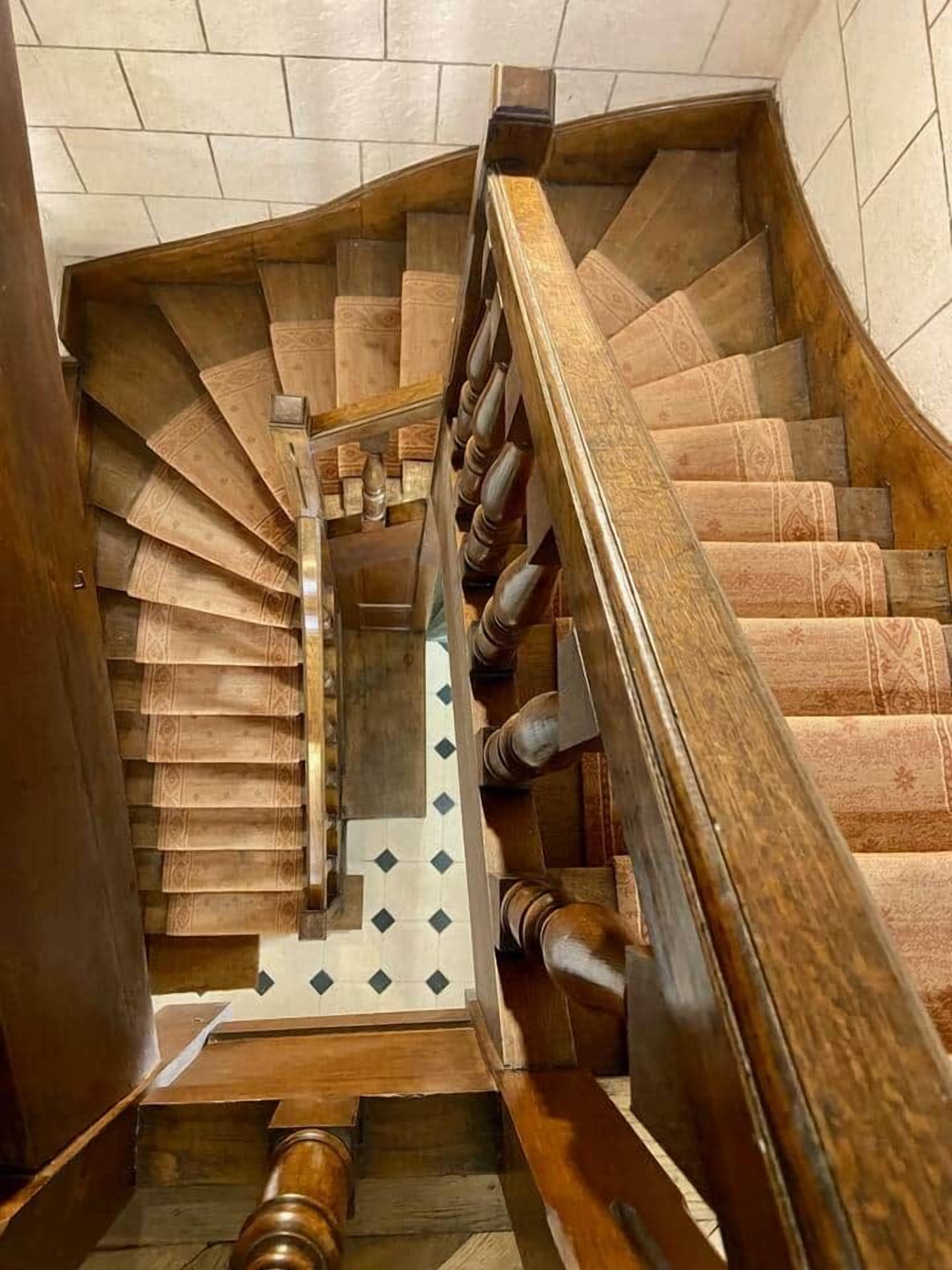 A spiral staircase with wooden steps and a wooden handrail.