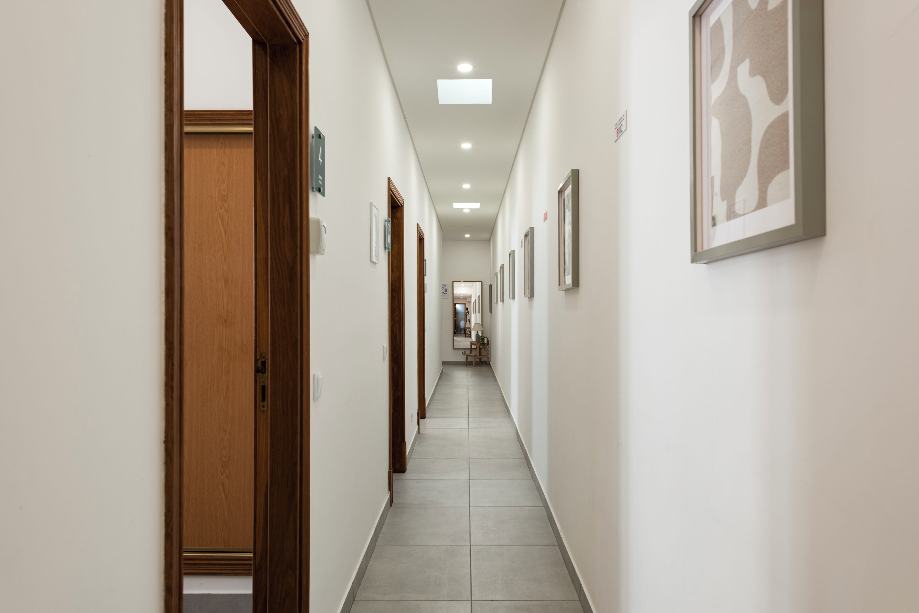 Bright, modern hallway with skylight and tile floors to guest rooms