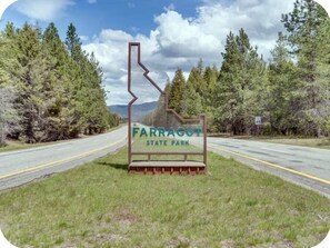 A road sign for Farragut State Park with a clear sky and trees in the background. -  Waterfront Home in Bayview with private boat dock on Lake Pend Oreille (Bayview)