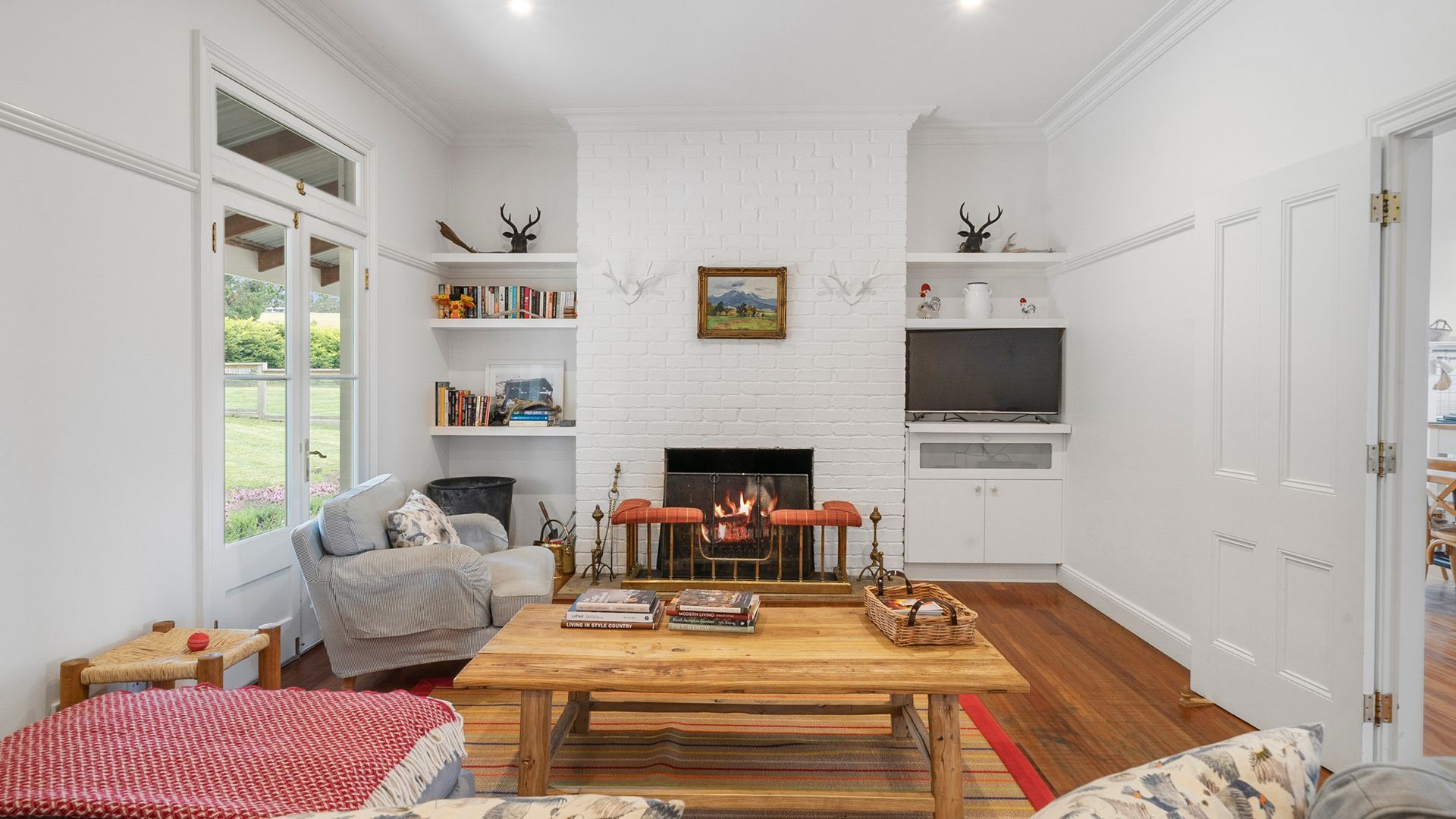 A cozy living room with a fireplace, bookshelves, and a television.